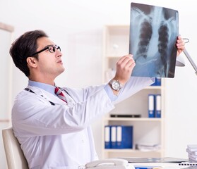 Young handsome doctor working in hospital room