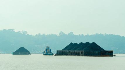Tugboat dragging barge full of coal, Mahakam River. Taken from behindTugboat dragging barge full of coal, Mahakam River. Taken from behind
