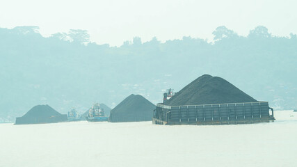 Tugboat dragging barge full of coal, Mahakam River. Taken from behindTugboat dragging barge full of coal, Mahakam River. Taken from behind