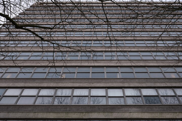 Low angle view of a post-war gray concrete office building with windows.