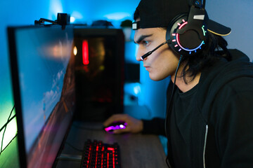 Side view of an attractive gamer focusing on winning a game