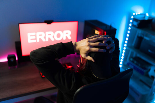 Rear view of an angry gamer losing a videogame