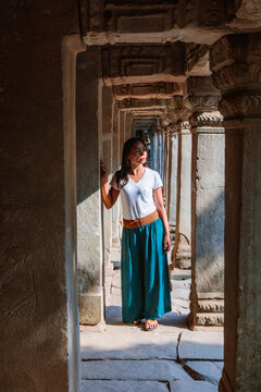 Woman walking in a corridor inside a temple, Angkor Wat