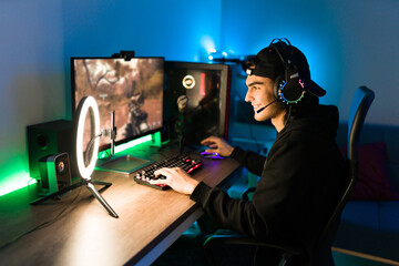 Latin man gaming on his PC during a live stream - obrazy, fototapety, plakaty