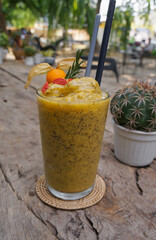 Soft focus Healthy smoothie with passion fruit and pineapple placed on a wooden table.