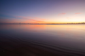 Obraz premium Peaceful dawn, colorful sky, smooth sea over wavy sands, island on horizon. Iriomote Island.