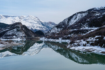 Snow-capped Pyrenees mountains reflected in the waters of the Lanuza reservoir