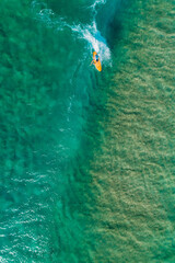 Surfer from above clean water riding waves