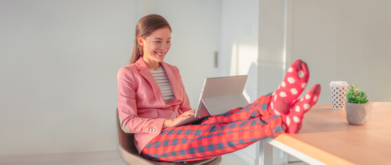 Working from home Asian woman streaming videoconference online in pajamas with suit blazer for remote work. Funny pandemic lifestyle concept panoramic banner.