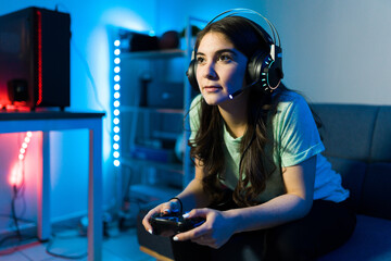 Woman using headphones and a microphone for a videogame - obrazy, fototapety, plakaty