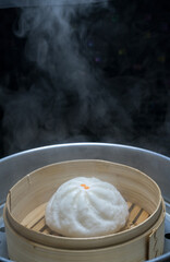 Steamed meat bun on hot steam pot, Hot steamed pork bun in bamboo steamer container.