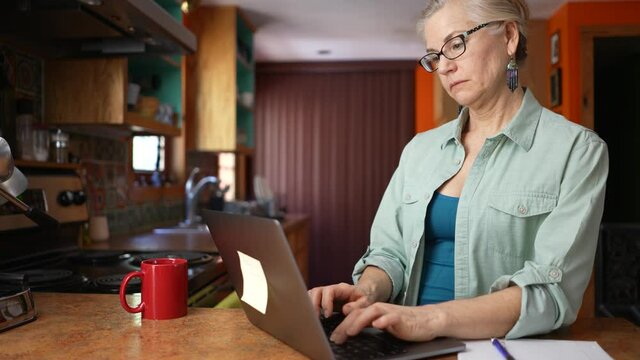Thoughtful serious mature woman working on laptop computer thinking solving problem. Concept of work from home businesswoman, teacher, tutor