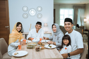 beautiful asian family enjoying their iftar dinner at home. ramadan kareem islam break fasting tradition