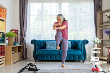 Retirement woman doing exercise with high knees pose at home