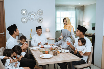 beautiful asian family enjoying their iftar dinner at home. ramadan kareem islam break fasting tradition