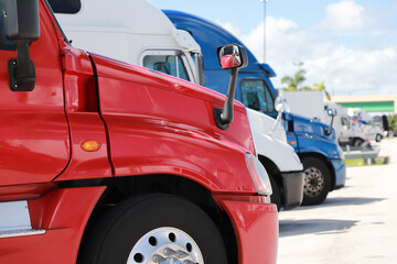 Red, white, blue, new trucks stand in the parking lot side view. Close up.
