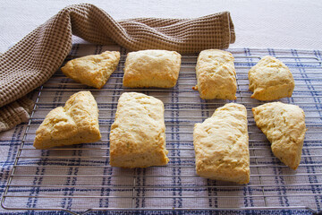 Golden homemade buttermilk biscuits on a cooling rack; delicious freshly baked scones from scratch