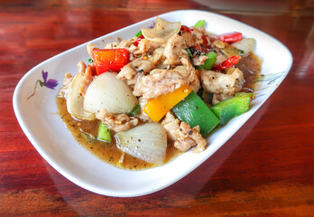 Stir-fried black pepper pork with sweet peper onion on wood table