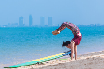 Sport woman yogini scorpion pose practice yoga exercise on the beach sea in relaxing day , yoga is...