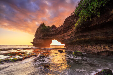 Dramatic Sunset color at Batu Bolong temple and Tanah Lot, Tabanan, Bali. beautiful view with the coral reef in low tide.