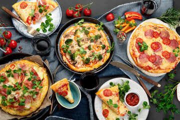 Delicious fresh pizzas variety with different souces and vegetables. Homemade food concept.
