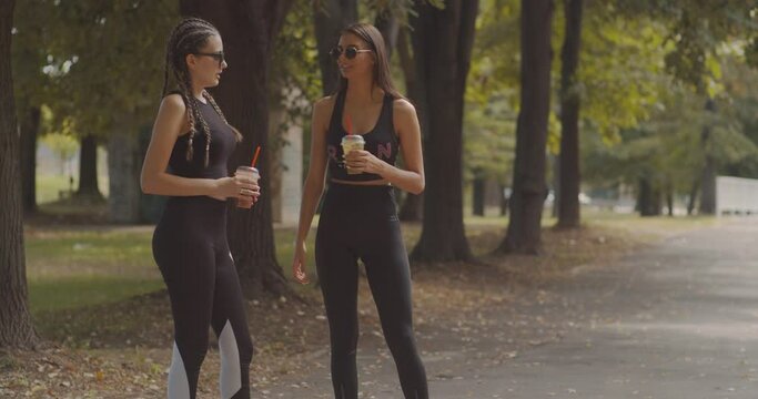 Two girls rollerskating in the park