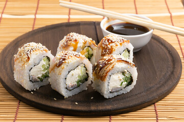 sushi, rolls on a plate with chopsticks, on a wooden background	
