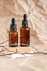 Cometic bottles made of amber glass on crumpled craft paper. Skin care products packaging design. Spa concept.