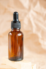 Cometic bottles made of amber glass on crumpled craft paper. Skin care products packaging design. Spa concept.