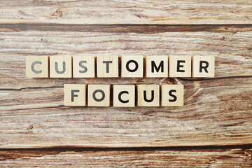 Customer Focus alphabet letter on wooden background