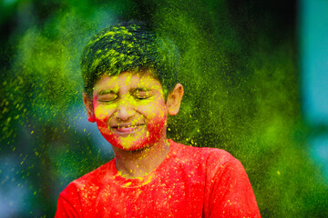 Holi celebrations -Indian little boy playing Holi and showing face expression.