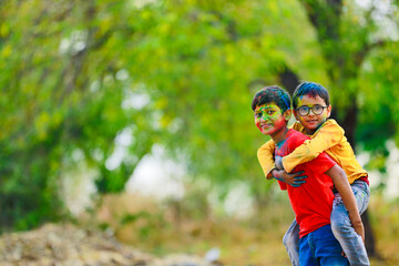 Naklejka premium Cute indian little child playing holi. Holi is colors festival in india