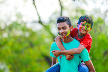 Naklejka premium Cute indian little child playing holi. Holi is colors festival in india