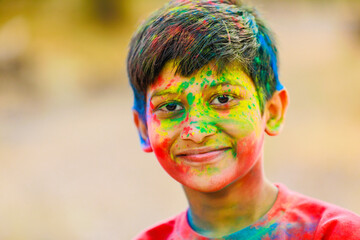 Holi celebrations -Indian little boy playing Holi and showing face expression.