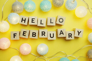 Hello February alphabet letter with LED Cotton ball Decoration on yellow background