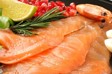 Appetizing slices of sliced salmon with lemon shrimp and pomegranate