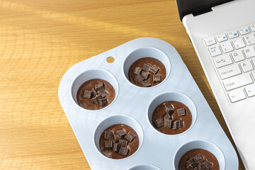 ノートパソコンを見てチョコレート菓子を作るイメージ
