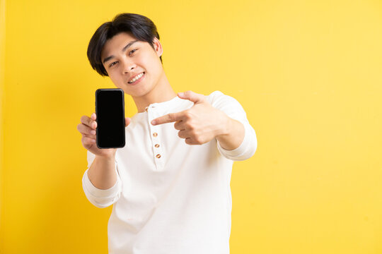 A Photo Of An Asian Man Pointing At A Phone With A Blank Screen