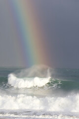 A stunning Vivid Rainbow formed over the Pacific Ocean close to where a large surfing competition is held in Chiba, Japan. There are large waves breaking onto the beach. It's close to Tokyo