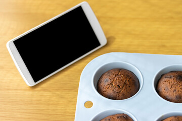 Fototapeta na wymiar スマートフォンを見てチョコレート菓子を作るイメージ