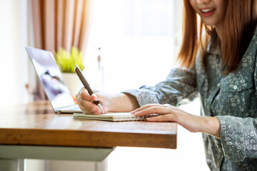 Businesswoman work from home wearing protection marks in covid-19 virus situation. Her working in quarantine for coronavirus and cleaning her hands with sanitizer or alcohol gel.