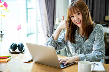 Businesswoman work from home wearing protection marks in covid-19 virus situation. Her working in quarantine for coronavirus and cleaning her hands with sanitizer or alcohol gel.