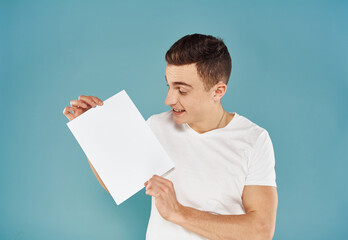 Male advertiser with a white sheet of paper on a blue background mockup Flyer