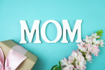 MOM alphabet letter with red flower and gift present on blue background