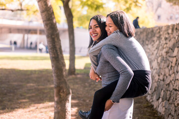 Smiling young latin mother and beautiful daughter having fun on the park.