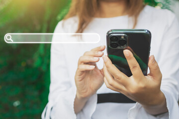 Close up woman hand hold using smart phone with search bar icon at outdoor background. Copy space of technology concept. Vintage tone filter effect color style.