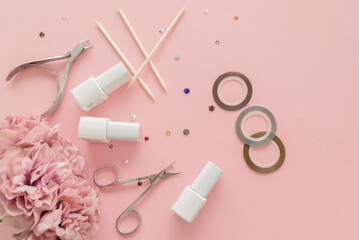 A set of manicure tools and accessories on a pink background with flowers and rhinestones. Nail care. Top view, flat lay. Copy space. Women's Day. March 8