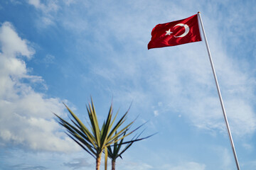 National Turkish flag waving against blue sky.