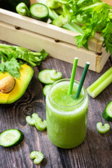 Vegan diet and nutrition, healthy detox, vegetarian concepts drinks. Green smoothie celery, avocado, cucumber and spinach on a rustic table.