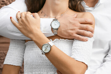 Happy young couple with stylish wrist watches, closeup